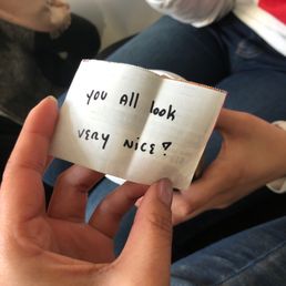 a person holding a piece of paper that says you all look very nice a person holding a piece of paper that says you all look very nice