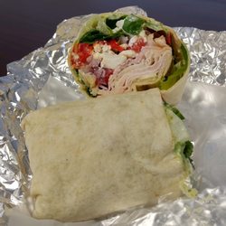 The Shop Eatery - Turkey Mediterranean Wrap: smoked turkey, feta, artichoke hearts, roasted red peppers, red onion, tomato, spinach & sundried tomato pesto.