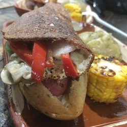 Xólotl - Los "xolos" están hechos con pan artesanal, salchicha asada de 100% carne de res, Corteza de queso adobera, vegetales frescos y aderezos.