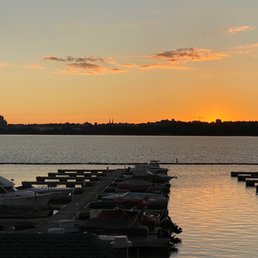 a sunset over a dock with boats a sunset over a dock with boats