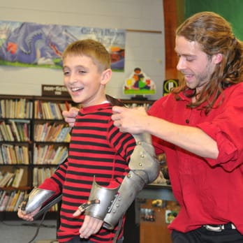 Days of Knights - A volunteer tries on real armor. - Performing Arts Near Me Days of Knights - A volunteer tries on real armor. - Performing Arts Near Me