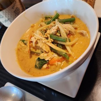 Noodlefan - Red curry (medium spice) - A bowl of Thai yellow curry with vegetables and chicken, served with fried spring rolls and other fried appetizers, along with a side of rice. - Thai Near Me - Castleton Corners, New York