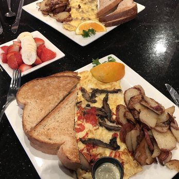 Keke's Breakfast Cafe - Breakfast is served. Portabella omelet and a turkey sausage and cheese omelet with a side of strawberries and banana - Breakfast & Brunch Near Me - St. Augustine, Florida
