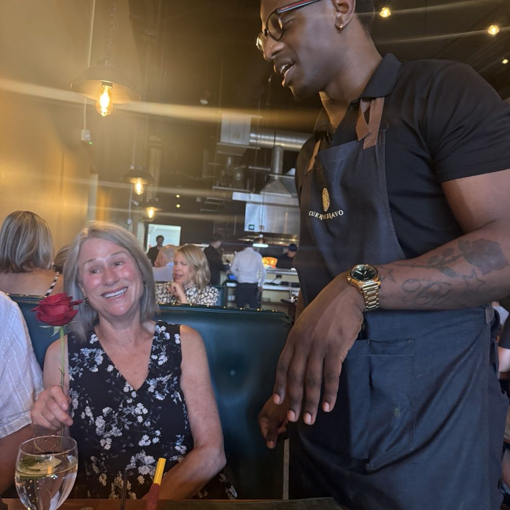 Cuerno Bravo Prime Steakhouse - Lovely server, Denzel, presenting a rose to my friend - Steakhouses Near Me - Tacoma, Washington