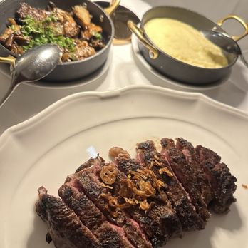 Delmonico's - SIGNATURE DELMONICO RIBEYE, POMMES PURÉE, and SAUTÉED WILD MUSHROOMS - Steakhouses Near Me - New York, New York Delmonico's - SIGNATURE DELMONICO RIBEYE, POMMES PURÉE, and SAUTÉED WILD MUSHROOMS - Steakhouses Near Me - New York, New York