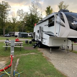 Top A Rise Campground - See where the door should be? And WHERE HIS SEWER PIPE IS?????? See our picnic table ON HIS LAWN? See another site RIGHT BEHIND US?