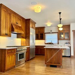 Frank & Fredy's Kitchen Cabinets - Wood kitchen cabinets with panel doors, glass uppers, and a matching island--built & installed in Los Feliz. Contact us to request a quote!