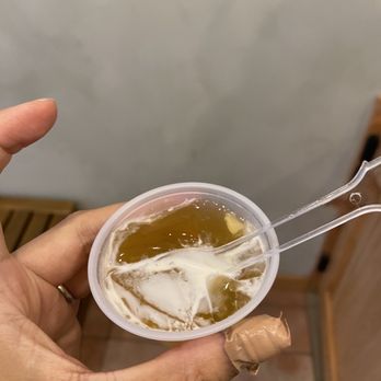 Tea Art - a person holding a cup of tea and a spoon - Bubble Tea Near Me - New York, New York