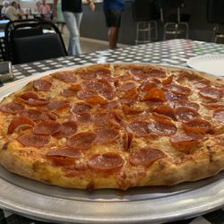 GiGi's Pizzeria - Dining room with large pepperoni pizza!