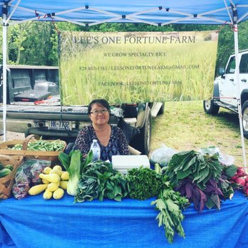 Riverside Tailgate Market - a woman sitting behind a table of fresh produce - Farmers Market Near Me - Woodfin, North Carolina Riverside Tailgate Market - a woman sitting behind a table of fresh produce - Farmers Market Near Me - Woodfin, North Carolina