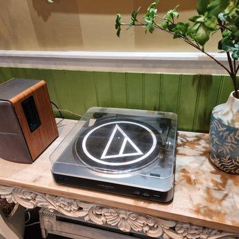 Mari Mari - a record player and a vase on a table - Noodles Near Me - Philadelphia, Pennsylvania