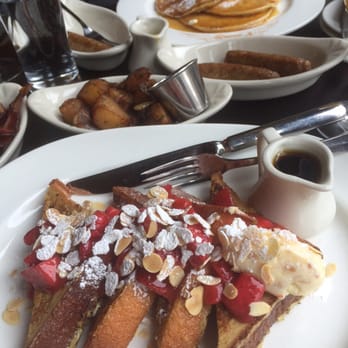 Parc - French toast w/ macerated strawberries, Lyonnaise potatoes, turkey sausage, pancakes in the back...Nueske bacon on the side. - French Near Me - Philadelphia, Pennsylvania