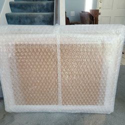 Sunshine Pack & Ship - Bubble wrapped pictures with cardboard box in the background.
