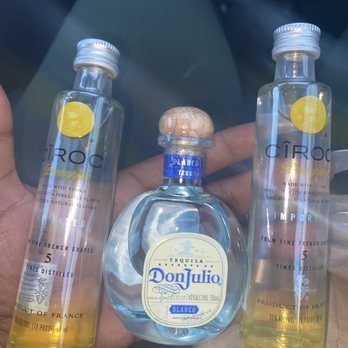 Liquor Outlet - a hand holding three bottles of liquor - Beer, Wine & Spirits Near Me - Las Vegas, Nevada