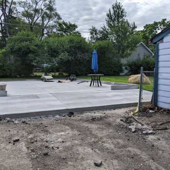 K&K Concrete - Garage pad, several wks later.  Looks great.  K&K  laid grass seed where hay stack is.   With watering the grass is growing in nicely. - Masonry/Concrete Near Me - Palatine, Illinois