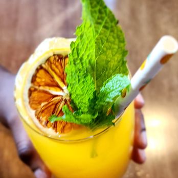The Spice Joint - a person holding a glass of orange juice - Caribbean Near Me - Jasper, Alberta The Spice Joint - a person holding a glass of orange juice - Caribbean Near Me - Jasper, Alberta