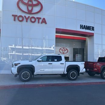 Hamer Toyota - Exterior of the building with two new vehicles for sale - Auto Repair Near Me - Mission Hills, California