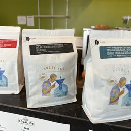three bags of coffee on a counter three bags of coffee on a counter