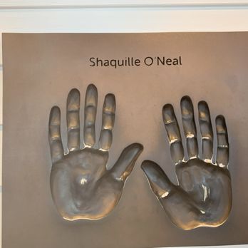 Big Chicken - Big hands - A metallic plaque displays two handprints and the name Shaquille O'Neal, mounted on a wall with horizontal paneling. - Chicken Shop Near Me