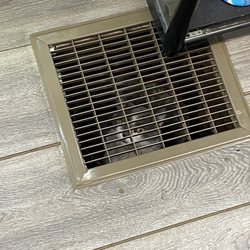 A crying cat stuck in a vent underneath a sales shelf