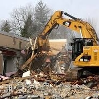 Eladio's Demolition - a bulldozer digging through a pile of rubble - General Contractors Near Me - San Diego, California Eladio's Demolition - a bulldozer digging through a pile of rubble - General Contractors Near Me - San Diego, California