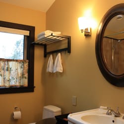 Red Barn Retreat Vacation Rental - View into bathroom with richly framed mirror flanked by pretty sconces.