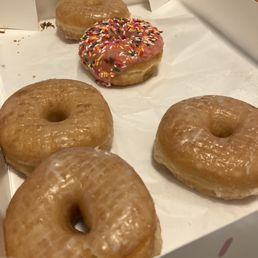 Classic glazed and a strawberry icing with sprinkles Classic glazed and a strawberry icing with sprinkles