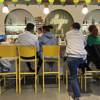 Alegria - a group of people sitting at a bar - Bars Near Me - Washington, DC, District of Columbia