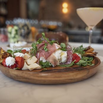 The Farm Italy - Antipasti platter with prosciutto, salami, burrata, cheese, roasted tomatoes, greens, and vegetables served on a wooden platter. - Italian Near Me - Uncasville, Connecticut The Farm Italy - Antipasti platter with prosciutto, salami, burrata, cheese, roasted tomatoes, greens, and vegetables served on a wooden platter. - Italian Near Me - Uncasville, Connecticut