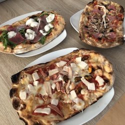 La Tavernetta - Vorne: Pinsa frutti di mare / Rechts: Pinsa Regina / Links: Pinsa Dolce Vita mit Büffelmozzarella