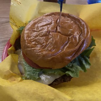 Southside Benderz - Impossible Burger - A burger with a homemade bun, lettuce, tomato, cheese, and a beef patty, served on yellow paper at a restaurant. - Burgers Near Me - Avon, Colorado
