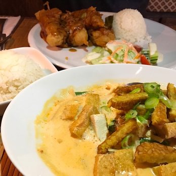 Tuk-Tuk - Tempe und Tofu in gelber Currysoße mit Reis, dahinter vegetarische Spieße mit Salat und Reis. - Indonesian Near Me - Berlin, BE
