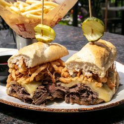 Redstone American Grill - Redstone Tenderloin Dip | 1/2lb of steak, hoagie, swiss, au jus, onion strings, horseradish sauce