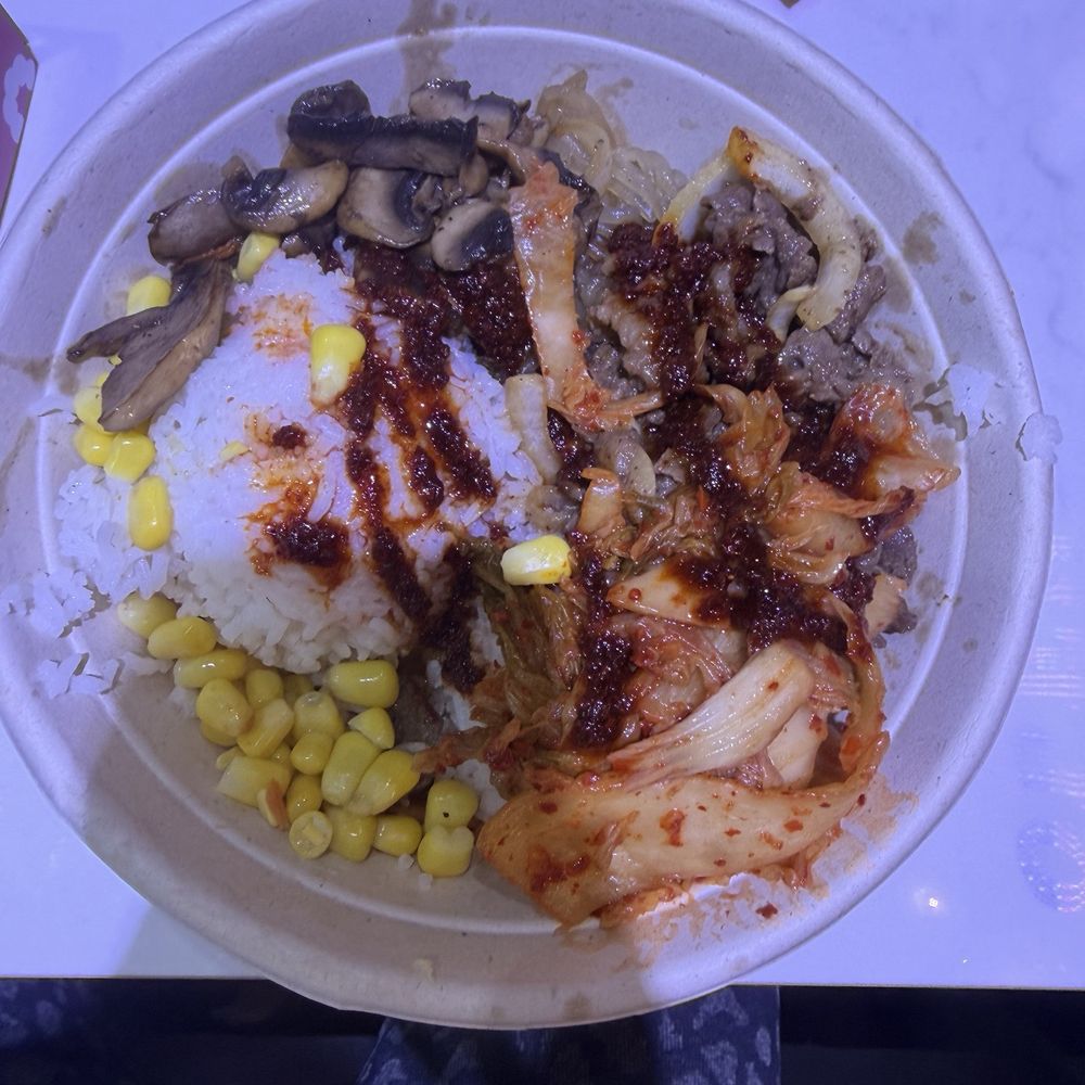 BiBimGo - Korean Rice Bowl - Rice and sweet potato noodle bowl w/ bulgogi beef, sweet corn, mushrooms and kimchi. Sweet chili sauce - Korean Near Me - Lutz, Florida BiBimGo - Korean Rice Bowl - Rice and sweet potato noodle bowl w/ bulgogi beef, sweet corn, mushrooms and kimchi. Sweet chili sauce - Korean Near Me - Lutz, Florida
