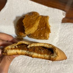 a hand holding a half eaten sandwich