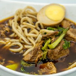 Four Four South Village - 111 Braised Beef Noodle Soup 紅燒牛肉麵: $14.95; $$16.28 with tax. With 601 Braised Egg 滷蛋, half shown: $2; $2.18 with tax. Take-out.