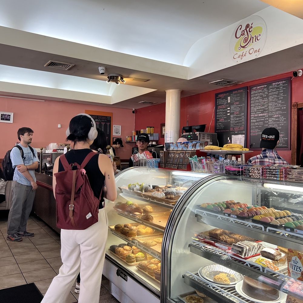 Cafe One - a woman standing in front of a display of pastries - Coffee & Tea Near Me - New York, New York Cafe One - a woman standing in front of a display of pastries - Coffee & Tea Near Me - New York, New York