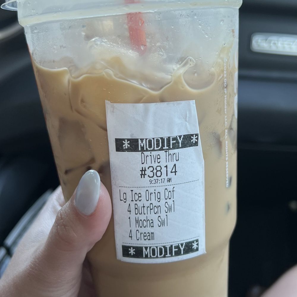 a hand holding a cup of iced coffee a hand holding a cup of iced coffee