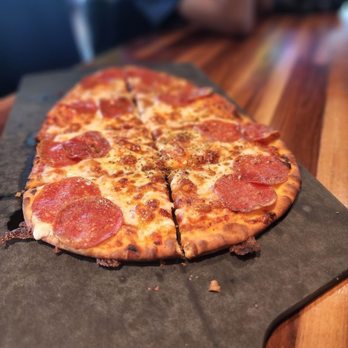 Topgolf - a pepperoni pizza on a cutting board - New American Near Me - Miami Gardens, Florida