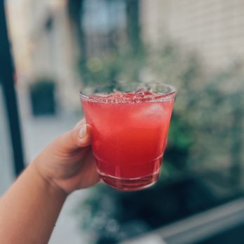 Ofrenda - a person holding a glass of red liquid - Mexican Near Me - New York, New York Ofrenda - a person holding a glass of red liquid - Mexican Near Me - New York, New York