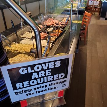 HuHot Mongolian Grill - a sign saying gloves are required before going through the food line - Asian Fusion Near Me - West Allis, Wisconsin