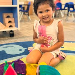 Sunshine House Preschool-Concord - Proud of her creation! Hands-on play with magnetic tiles builds critical thinking and fine motor skills.