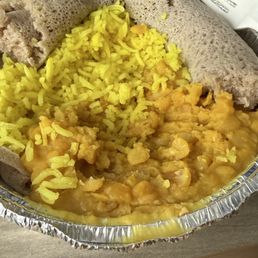 Kik Alicha (yellow split peas) with injera bread, and a side of rice (addon). Packaged to go.