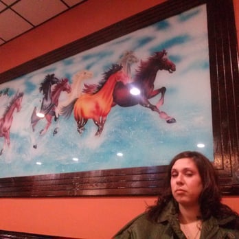 Supreme China Buffet - a woman sitting in front of a painting of horses - Chinese Near Me - Goshen, Indiana
