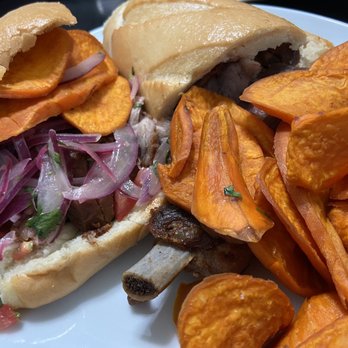 El Rocoto - Pan Con Chicharrones after adding the sweet potatoes and Salsa Criolla (this is how you eat it in Peru) - Peruvian Near Me - Gardena, California El Rocoto - Pan Con Chicharrones after adding the sweet potatoes and Salsa Criolla (this is how you eat it in Peru) - Peruvian Near Me - Gardena, California