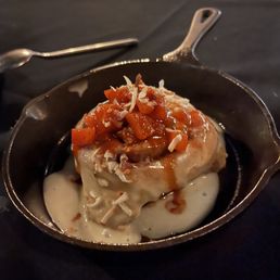 Cinnamon Roll with spiced-apple mixture and coconut creme icing. Served in a warm iron dish.