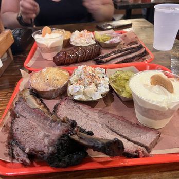 Terry Black's Barbecue - Beef rib and brisket with cornbread, potato salad, side of pickles and banana pudding - Barbeque Near Me - Austin, Texas Terry Black's Barbecue - Beef rib and brisket with cornbread, potato salad, side of pickles and banana pudding - Barbeque Near Me - Austin, Texas