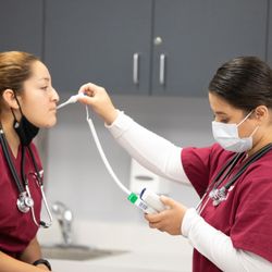 UEI College - Garden Grove - Medical Assistant students performing tasks on each other.