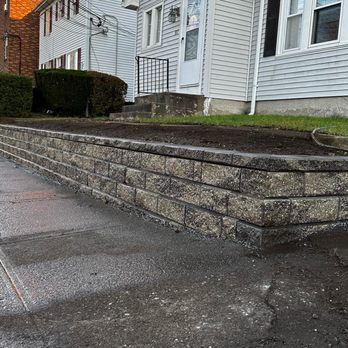Simone & Sons Landscape Construction - a stone retaining wall in front of a house - Landscaping Near Me Simone & Sons Landscape Construction - a stone retaining wall in front of a house - Landscaping Near Me