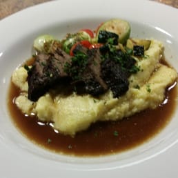 Boneless braised beef in a red wine reduction on top of cheesy polenta